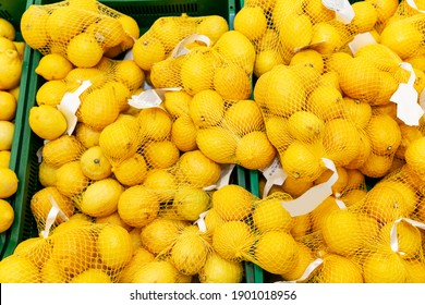 Fresh lemons in factory nets on the counter in the store.