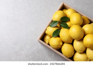 Fresh lemons in wooden crate on grey table, top view. Space for text - Powered by Shutterstock