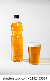 Fresh light draft beer in a plastic bottle. Beer with foam poured into a glass on a white background