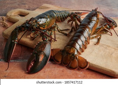 Fresh lobsters ready to be cooked, on wooden background - Shutterstock ID 1857417112