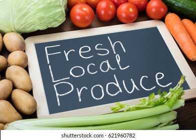 Fresh Local Produce Written On Slate With Various Vegetables On Table