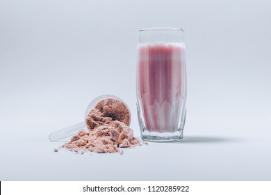 Fresh Made Whey Protein Shake In A Glass And Scoop Of Fine Powder On White Table. Sports Supplements Drink.