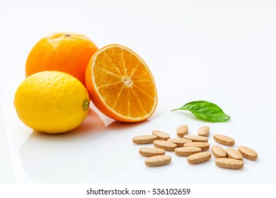 Fresh Mandarin Orange,lemon And Vitamin C Tablets On White Background. In Concept Of Vitamin C.Supplementary Health Food Nutrition.Benefits Of Vitamin C.Fruits VS Supplementary Food.Choice For Health.