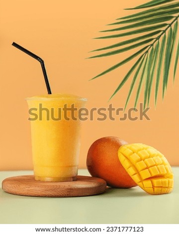 Fresh Mango Juice in wood podium with piece of mango 