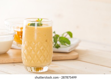 fresh mango smoothie on wood background