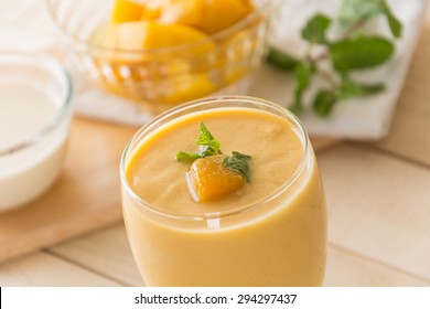 fresh mango smoothie on wood background