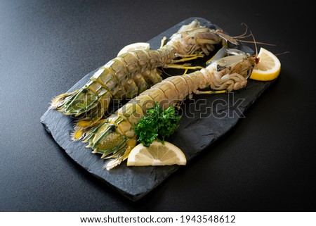 fresh mantis shrimp with lemon on black board