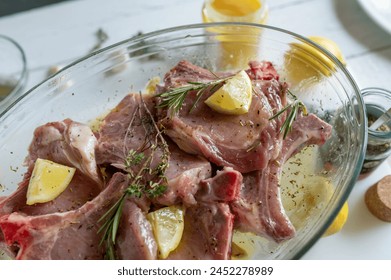 Fresh marinated pork chops with olive oil, lemon, honey, garlic and thyme in a bowl. Delicious barbecue meat - Powered by Shutterstock