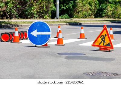 Fresh Markings At The Pedestrian Crossing Are Fenced With Traffic Bypass Signs And Orange Traffic Cones. Copy Space.