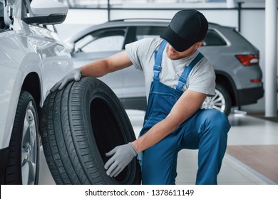 Fresh material. Mechanic holding a tire at the repair garage. Replacement of winter and summer tires.