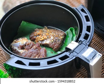 Fresh Meat Grilled With Air Fryer On Banana Leaf On The Rattan Table.Ready To Cook.Outdoor,balcony,garden.Spices.