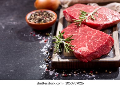 fresh meat with ingredients for cooking on dark table