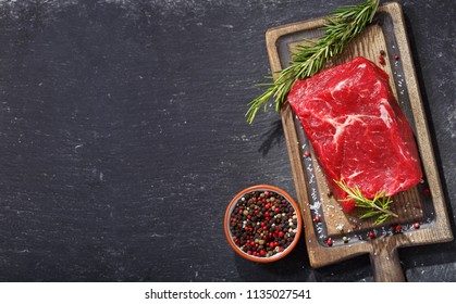 fresh meat with ingredients for cooking on wooden board, top view - Shutterstock ID 1135027541