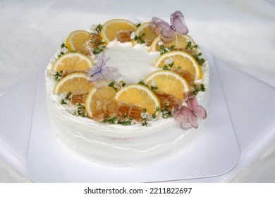 Fresh Milk Cream Cake On Top Decorated With Orange Slices, Honey, White Flowers And Butterflies. Dessert Menu And Coffee Shop. Front Focus