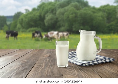 Fresh milk in glass on dark wooden tabletop and blurred landscape with cow on meadow. Healthy eating. Rustic style. Space for design. - Shutterstock ID 1464216647
