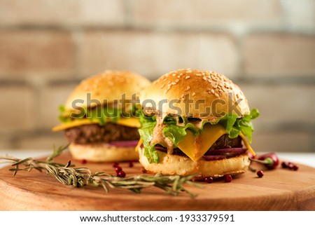 Fresh mini burgers on a deerved tray against a brick wall