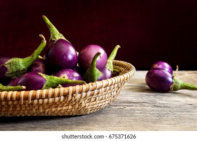 Fresh Mini Purple Eggplant In Basket On Wooden Background. Eggplant Has Benefits To Help Build Strong Bones, Prevent Osteoporosis And Cancer, Help Lose Weight And Manage Diabetes.