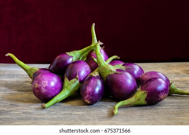 Fresh Mini Purple Eggplant On Wooden Background. Eggplant Has Benefits To Help Build Strong Bones, Prevent Osteoporosis And Cancer, Help Lose Weight And Manage Diabetes.