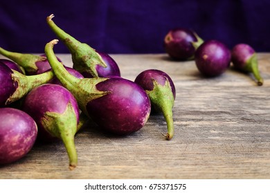 Fresh Mini Purple Eggplant On Wooden Background. Eggplant Has Benefits To Help Build Strong Bones, Prevent Osteoporosis And Cancer, Help Lose Weight And Manage Diabetes.