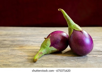 Fresh Mini Purple Eggplant On Wooden Background. Eggplant Has Benefits To Help Build Strong Bones, Prevent Osteoporosis And Cancer, Help Lose Weight And Manage Diabetes.