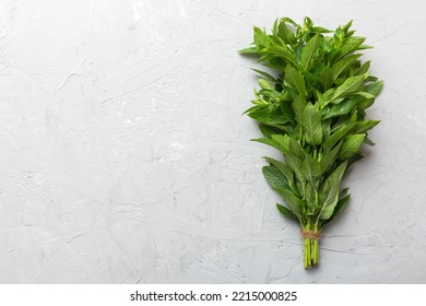 Fresh mint bunch on colored table. Top view with copy space. - Shutterstock ID 2215000825