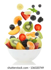 Fresh Mixed Fruit Salad Falling Into A Bowl Of Salad. White Isolated