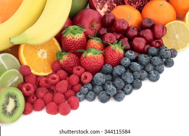 Fresh mixed fruit superfood background selection with fruits high in antioxidants, vitamin c and dietary fibre with copy space.