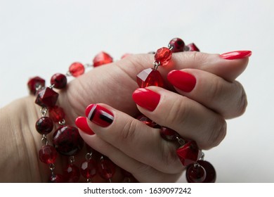 fresh modern manicure, red nails, one of the nails has an abstract drawing. In the hand jewelry, accessories, red beads. - Shutterstock ID 1639097242