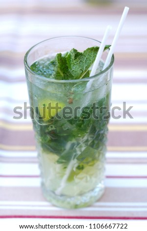 Fresh mojito from mint and lime in a glass on the table.