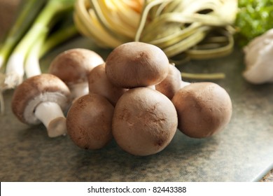 Fresh mushrooms with other ingredients in the background.