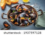 Fresh mussels in a pan, with parsley and lemon