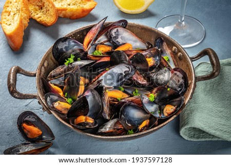 Fresh mussels in a pan, with parsley and lemon