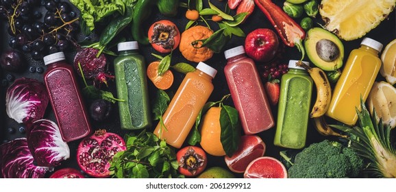 Fresh natural colorful organic juices over ingredients background, wide composition - Shutterstock ID 2061299912