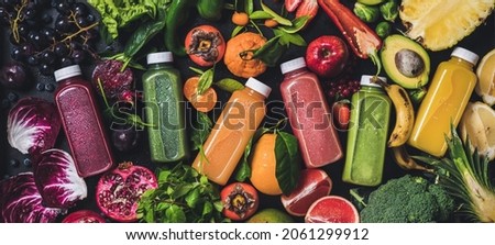 Fresh natural colorful organic juices over ingredients background, wide composition