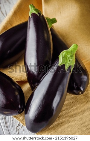 fresh natural eggplant on a light white wooden rustic background.