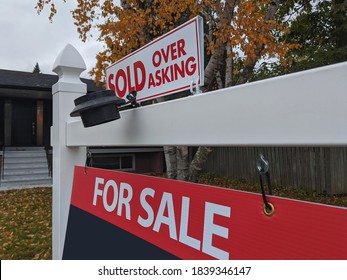 Fresh new sign sold over asking for sale in front of detached house in residential area. Real estate bubble, crash, hot housing market, overpriced property, buyer activity concept. Selective focus. - Shutterstock ID 1839346147