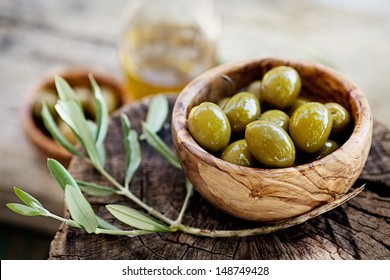 Fresh olives and olive oil  on rustic wooden background. Olives in olive wood. - Powered by Shutterstock