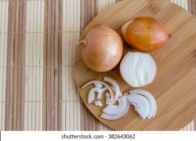 Fresh onions sliced on a cutting board, top view