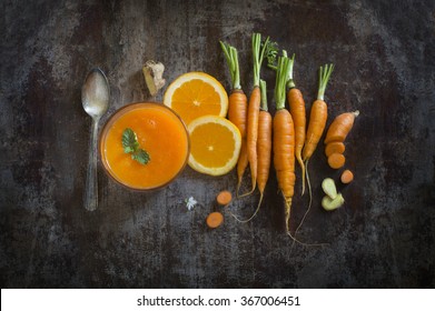 Fresh Orange And Carrot Juice On Moody Rustic Wooden Background.