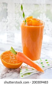 Fresh orange and carrot smoothie on marbled background