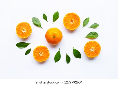 Frische orangefarbene Zitrusfrüchte mit grünen Blättern auf weißem Hintergrund.