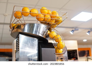 Fresh orange fruits in orange juice machine at store. Juicer in the supermarket. - Powered by Shutterstock