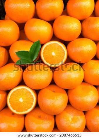 fresh orange fruits with leaves as background, top view