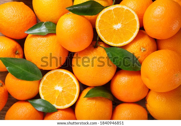 fresh\
orange fruits with leaves as background, top\
view