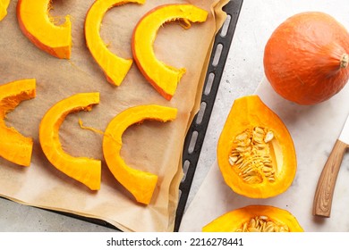 Fresh Orange Hokkaido Pumpkin Cut In Half On White Marble Cutting Board, Slices Of Pumpkin On Baking Paper