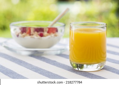 Fresh orange juice and bowl of muesli in garden - Powered by Shutterstock