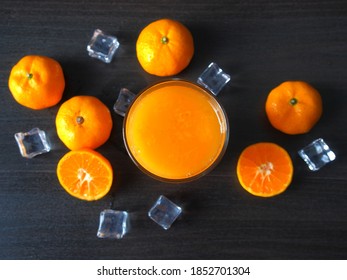 Fresh Orange Juice With Orange Fruit And Ice Cube Topview On Dark Color Table.