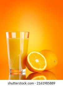 Fresh orange juice in a glass and half of orange fruit over orange background - Shutterstock ID 2161985889