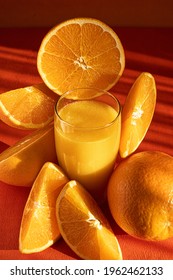 Fresh Orange Juice In Glass And Orange Slices.Orange Background.Monochromatic Food Photography.