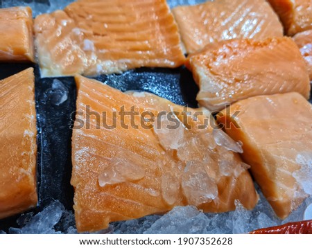 fresh orange salmon fillet on black background with ice